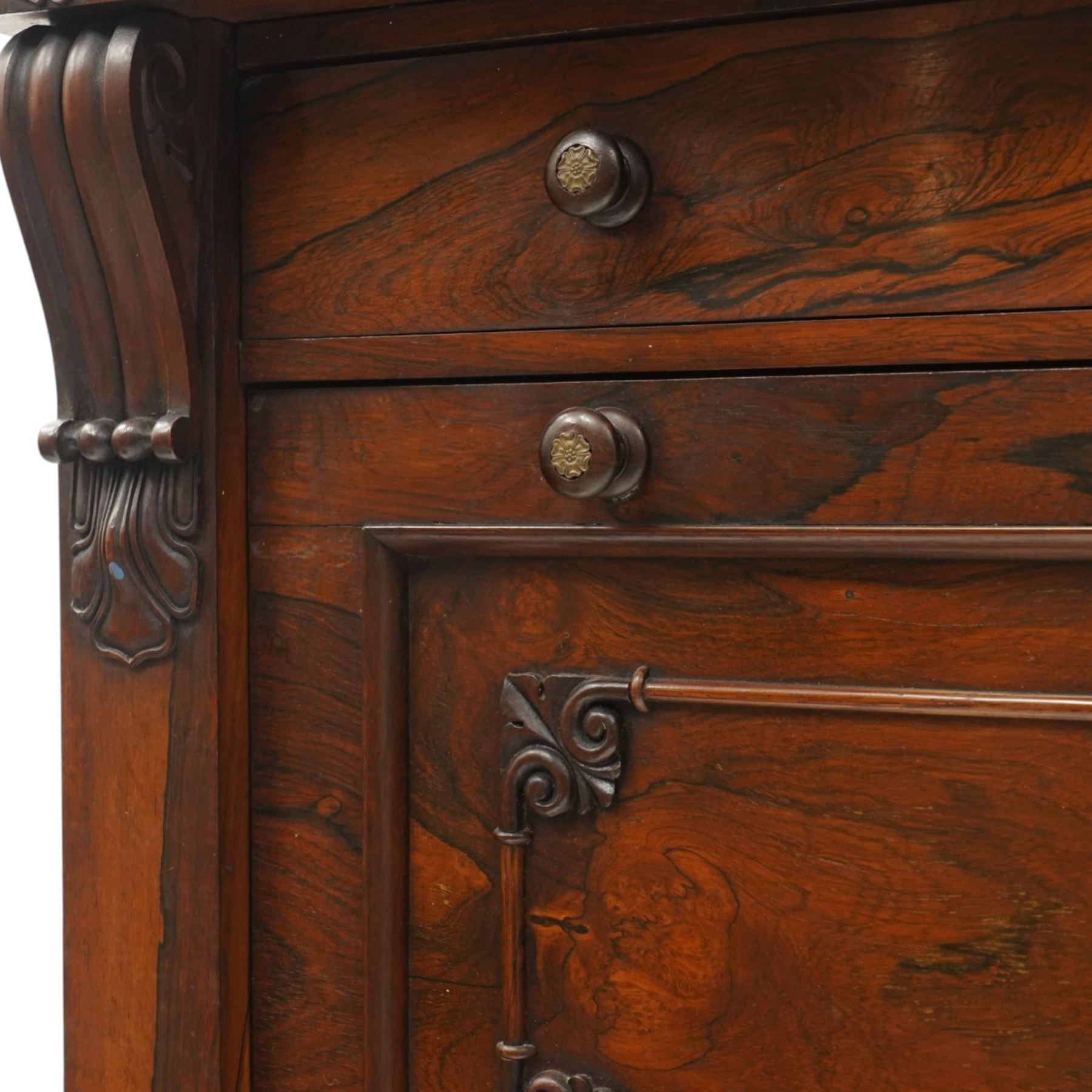 Victorian rosewood Wellington secretaire chest, the projecting stepped cornice over a banded frieze with moulded rosette mounts, single drawer over a secretaire fall-front opening to reveal a maple lined interior with assorted pigeonholes and correspondence drawers, over a lappet carved lower edge with four graduating drawers below, each with turned pull handles, flanked by hinged lock to the right and plain stile to the left surmounted by reeded corbels, raised on a skirted base