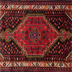 North west Persian Koliahee hand-knotted rug, central magenta field with elongated hexagonal medallion and arrow-shaped pendants over a dark lozenge-filled panels and stepped spandrels filled with boteh and floral motifs, corner square and cruciform devices within a pale olive border of stylized rosettes and angular vines between narrow guard stripes 