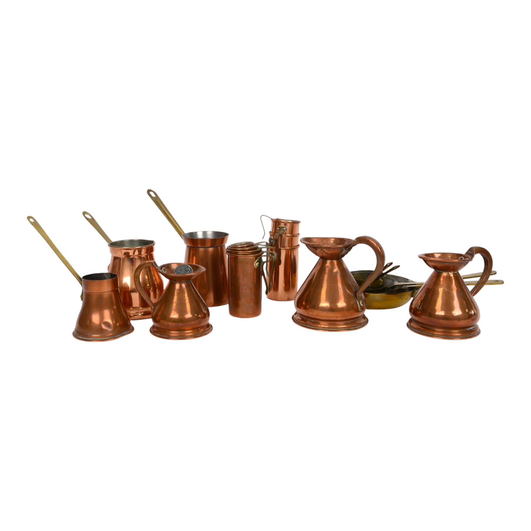Copper and brass measures, including set of three copper jugs, set of four graduating brass pans and two sets of copper and brass cup measures