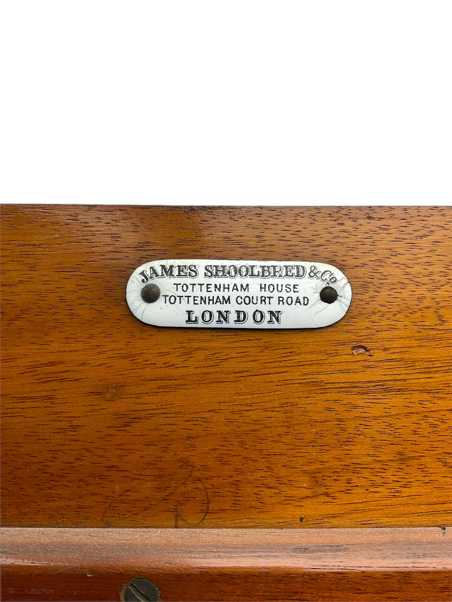 James Shoolbred & Co. London - Edwardian inlaid mahogany triple combination wardrobe, projecting dentil cornice over bevel glazed door, two figured oval panelled doors and four drawers, the central compartment fitted with linen slides and drawers, satinwood banding, on base with shaped apron and bracket feet, with enamel plaque 