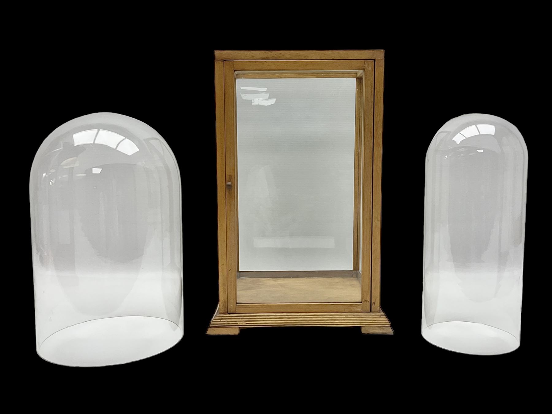 Tabletop glass display cabinet, with hinged door, together with two glass domes
