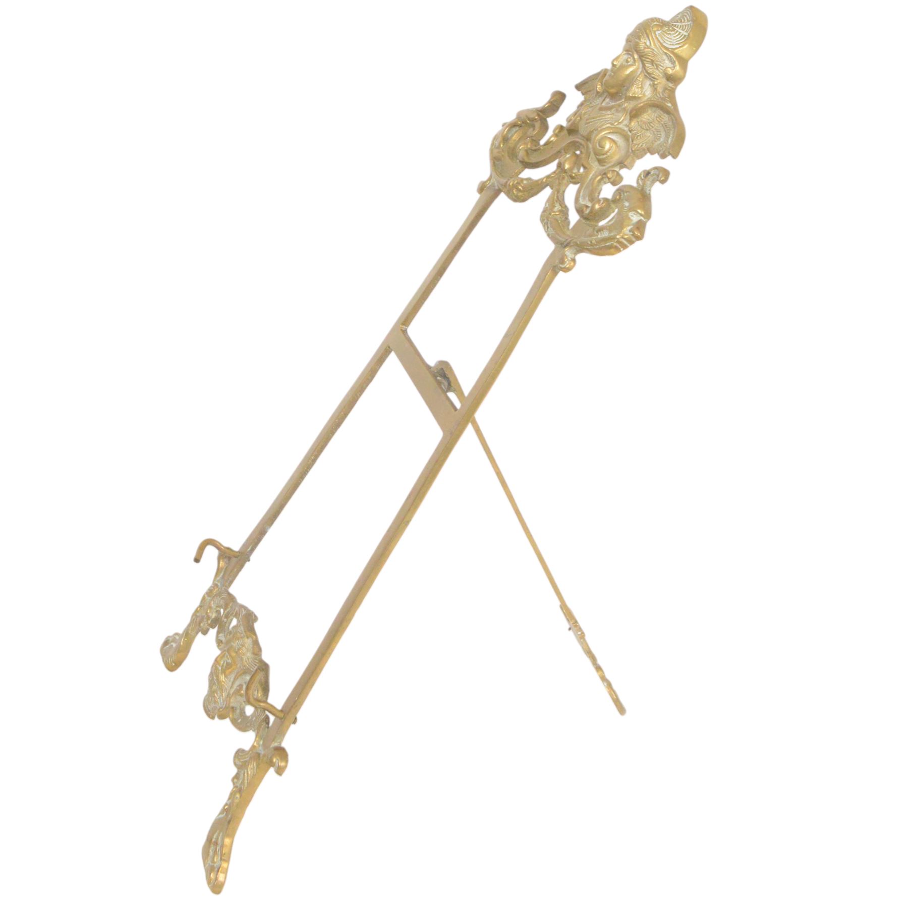 Three Baroque design brass table easels, the largest with cast mask detail, H47cm, and two matched graduated examples, smallest H25cm