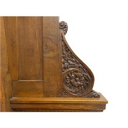 19th century oak enclosed pew, egg and dart moulded cornice over high fielded panelled wingback, fitted with foliage scroll and flower head carved brackets