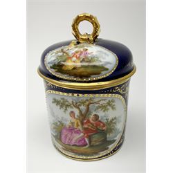 Berlin cabinet chocolate cup and saucer, circa 1900, the cup with angular gilt handle, the domed cover with ribbon modelled ring handle, each hand painted with oval panels of courting couples against a dark blue ground heightened with gilt, each with blue sceptre mark beneath, cup including cover H10.5cm, saucer D13.5cm,