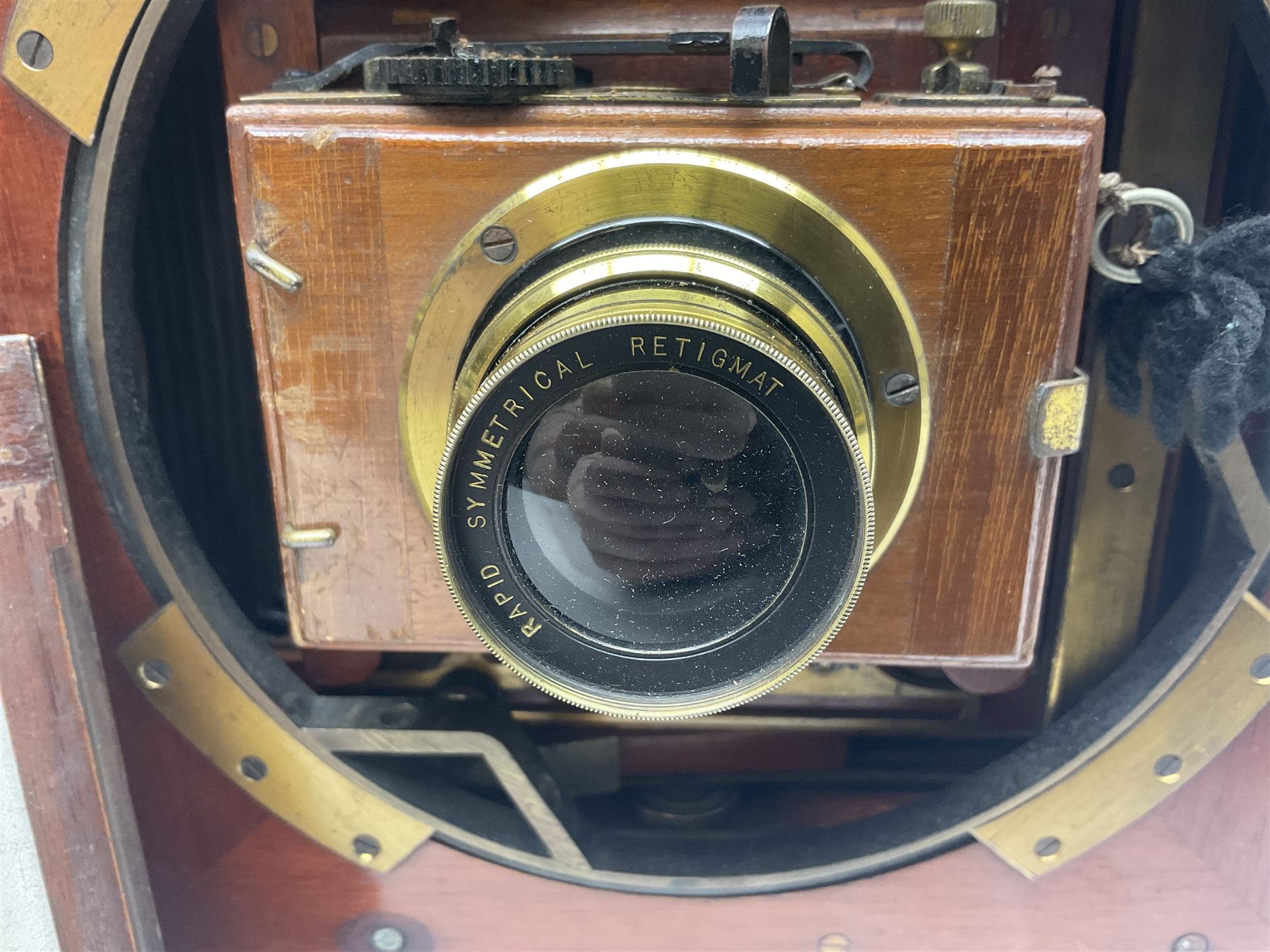Folding plate camera in mahogany and lacquered brass, with Rapid Symmetrical Reetigmat len and two dark slides in canvas case