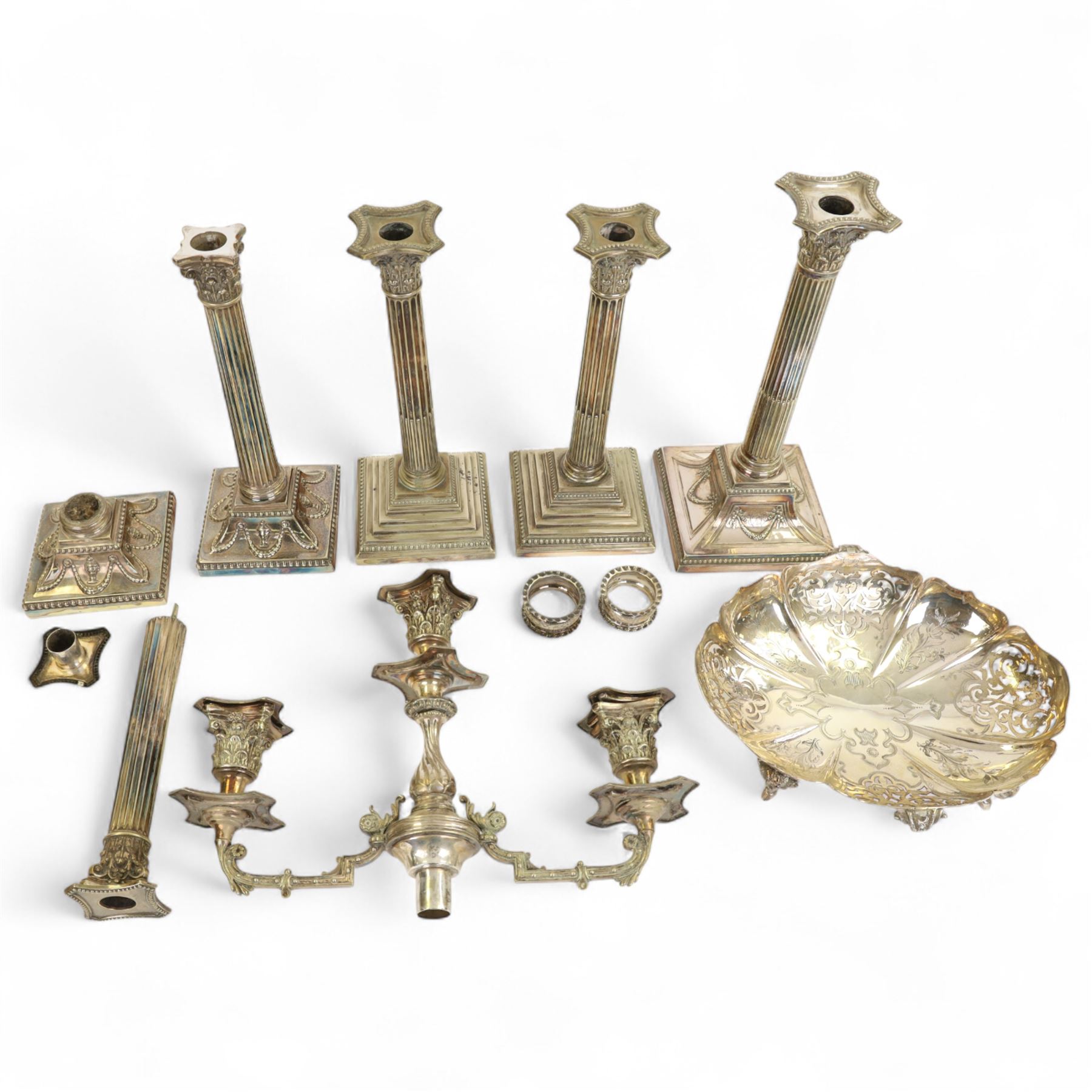 Pair of silver napkin rings, hallmarked, together with a silver plated pierced bowl with cast ram handles and feet, four silver plated candlesticks and a candelabrum