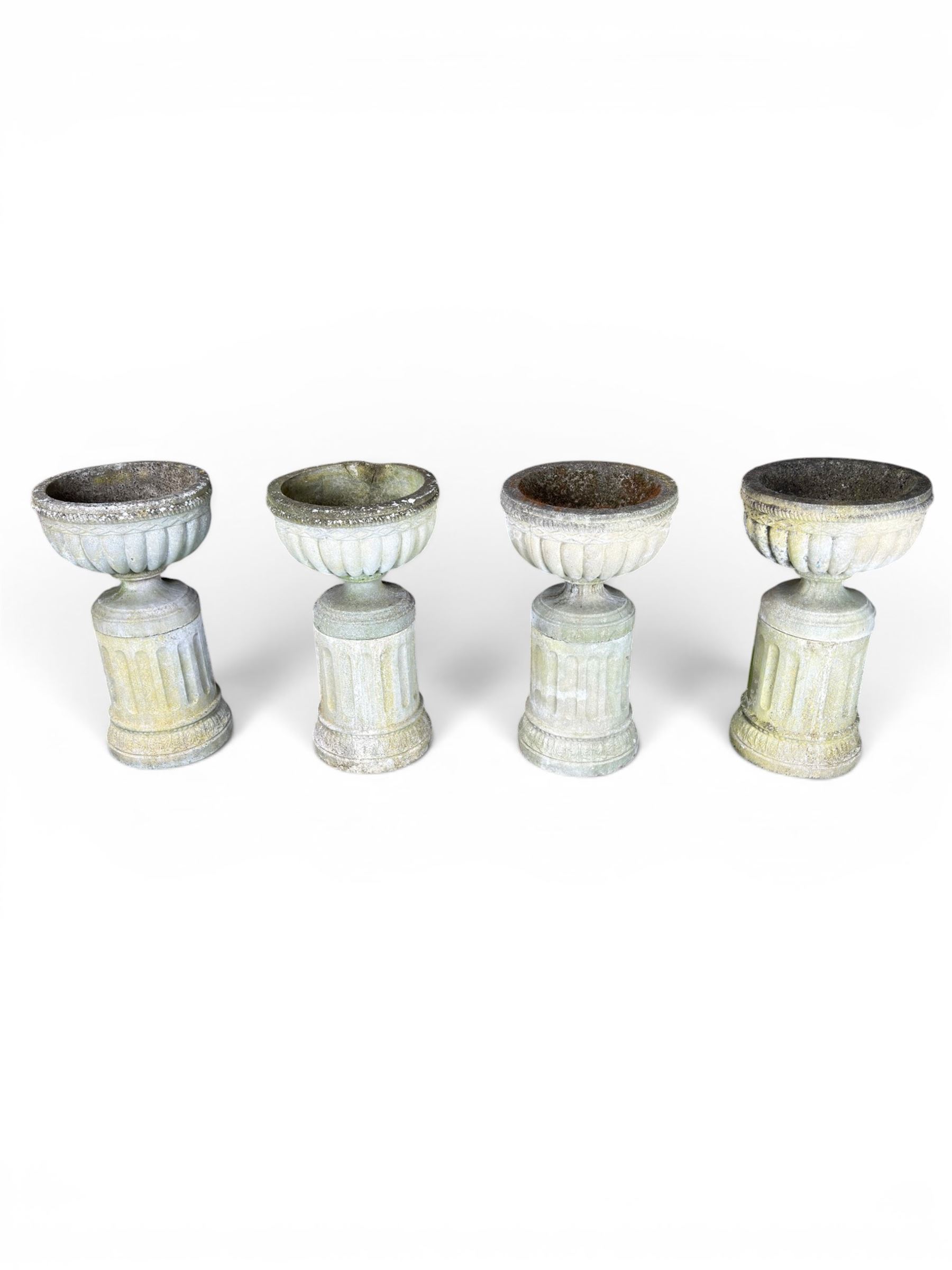 Four 20th century good quality weathered cast stone pedestal urns, circular lobed bowls with rope twist and lattice border, raised on squat base with fluted columns