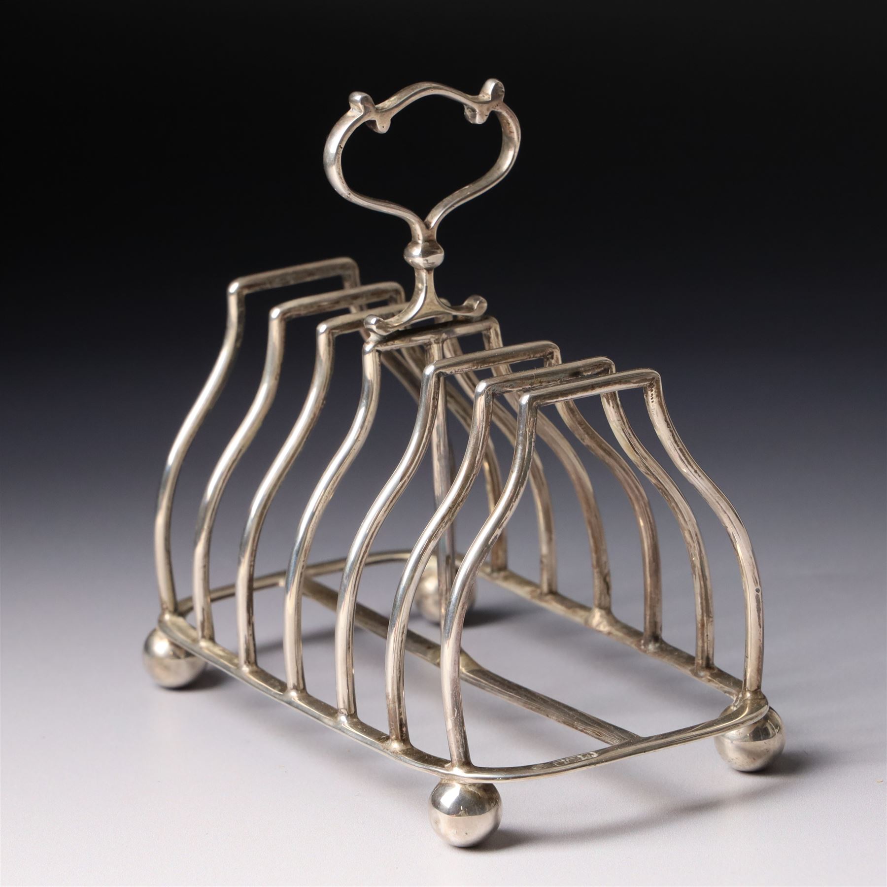 Edwardian silver six division toast rack with loop handle and ball feet Sheffield 1908 Maker Martin Hall & Co