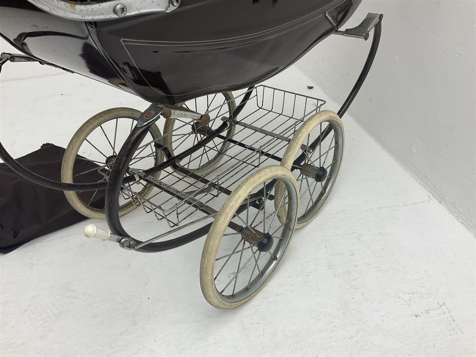 Pair of 1980s Silver Cross brown coach built dolls prams; each with folding canopy and apron, tubular framework with suspension, spoked wheels with brake and luggage rack and separate matching shopping bag L93cm