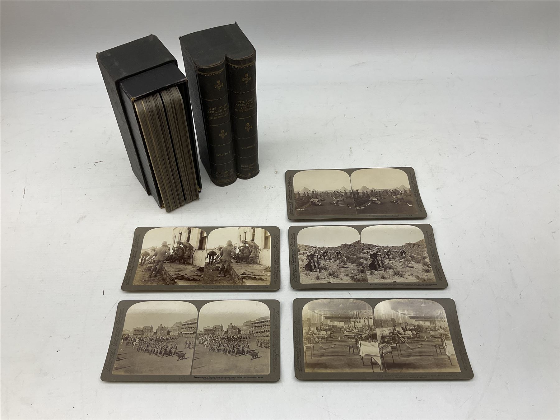 Early 20th century hand held slide action stereoscope viewer, Underwood & Underwood, publishers: The South African War through the stereoscope, stereo photographs mounted on card and captioned, in two double volume book form boxes with title labels and Underwood & Underwood  publishers: Hunting series through the stereoscope, stereo photographs mounted on card and captioned, in a single volume book form box   