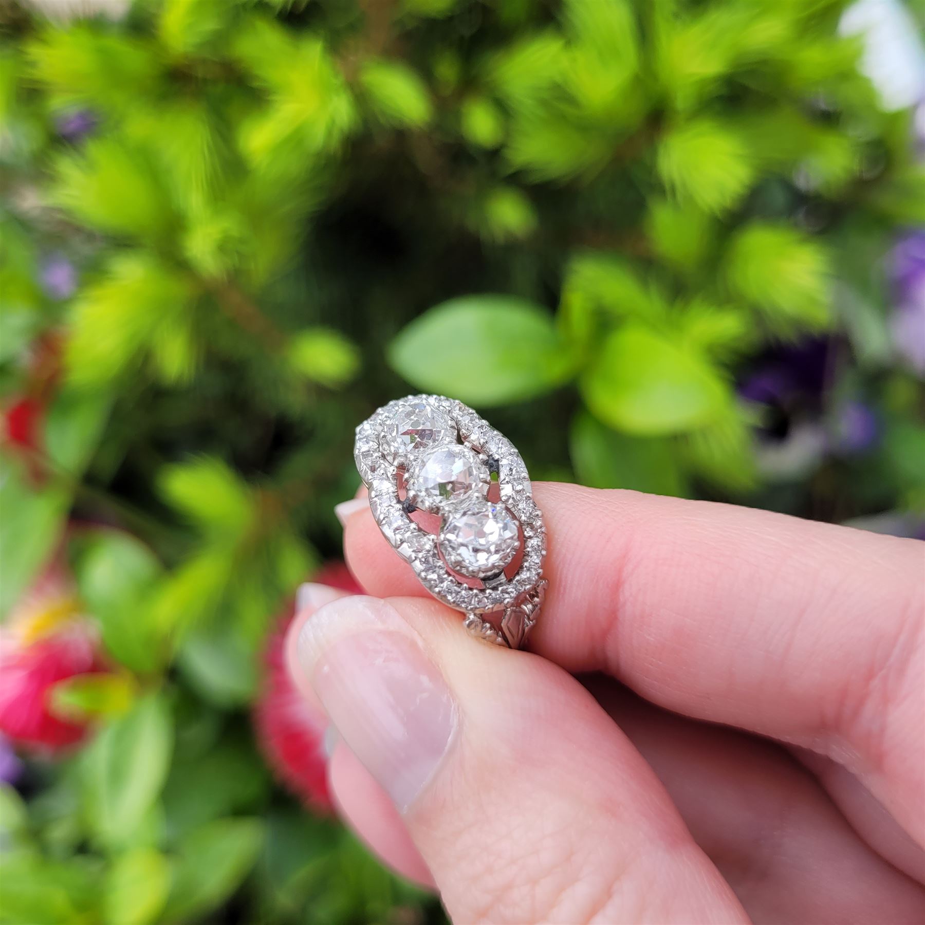 Late 19th / early 20th century platinum diamond ring, three old cut diamonds, in an openwork setting surrounded by further old cut diamonds, with pierced design shoulders, principal three diamonds total weight approx 1.45 carat, in a velvet and silk lined box by Selfridges