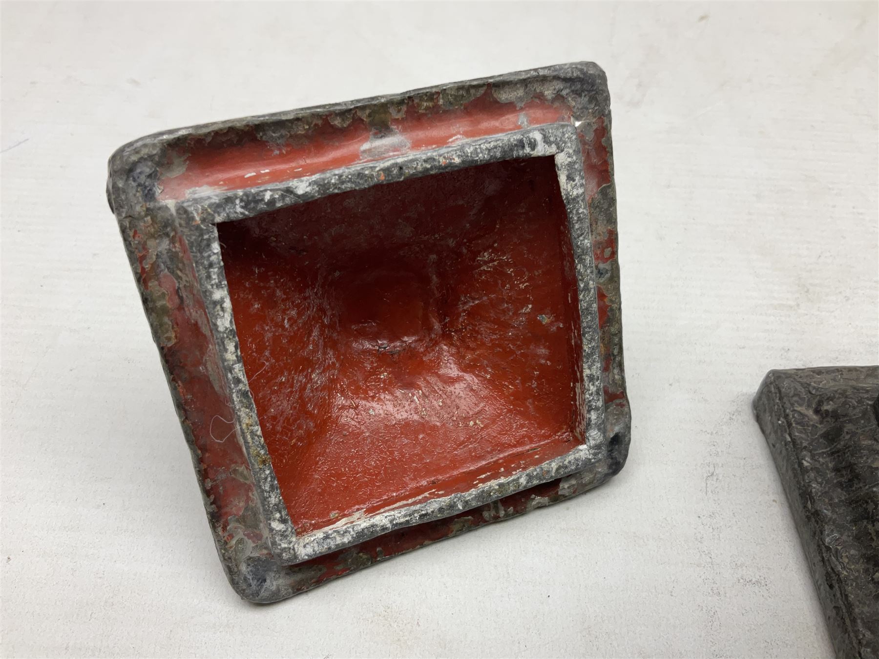 19th century lead tobacco box, the body of square form decorated with panels of courting couples in relief supporting stepped tapering lid with figural male head finial, H18.5cm