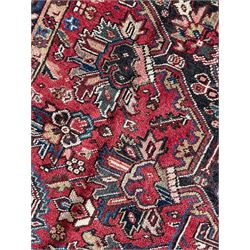 Persian Heriz red ground rug, large medallion decorated with palmettes and Ejder motifs, the border decorated with stylised plant motifs, within floral design guard stripes 