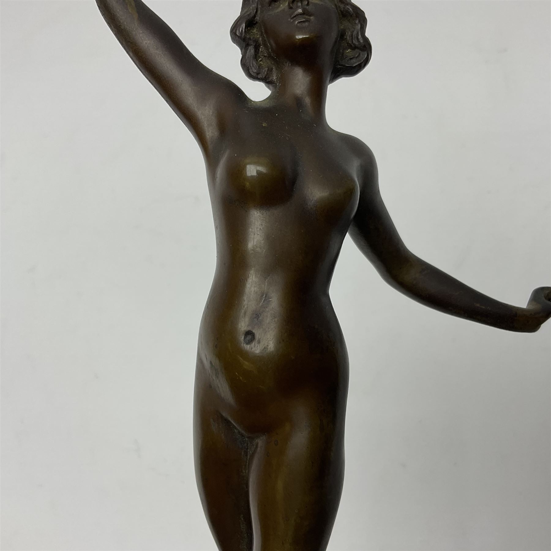 Bronze figure modelled as a nude woman with one arm raised a crescent moon upon her forehead, raised upon a circular stepped plinth, H36cm