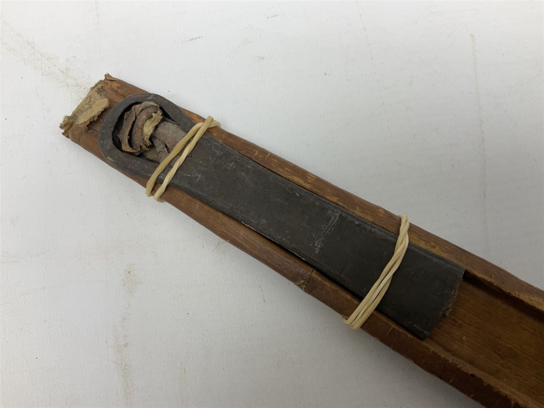 Tuareg Takoba sword with 78.5cm triple fullered blade incised with two crescent moons to either side, metal hilt with stylised floral designs to the cross-guard, decorative grip and disc form pommel cap; in tooled leather scabbard decorated with geometric designs L92cm overall; and an Indian Tulwar sword with 75cm plain curving blade and 'silver' damascened hilt (no scabbard) (2)