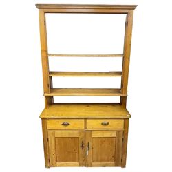 19th century polished pine dresser, the dresser rack fitted with three shelves, the base with two drawers over two panelled cupboards