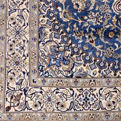 Central Persian Nain hand-knotted rug, soft blue field with central medallion with finely drawn scrolling palmettes and floral tendrils, with ivory spandrels, enclosed by a floral meander border flanked by multiple guard stripes with cotton fringe ends 