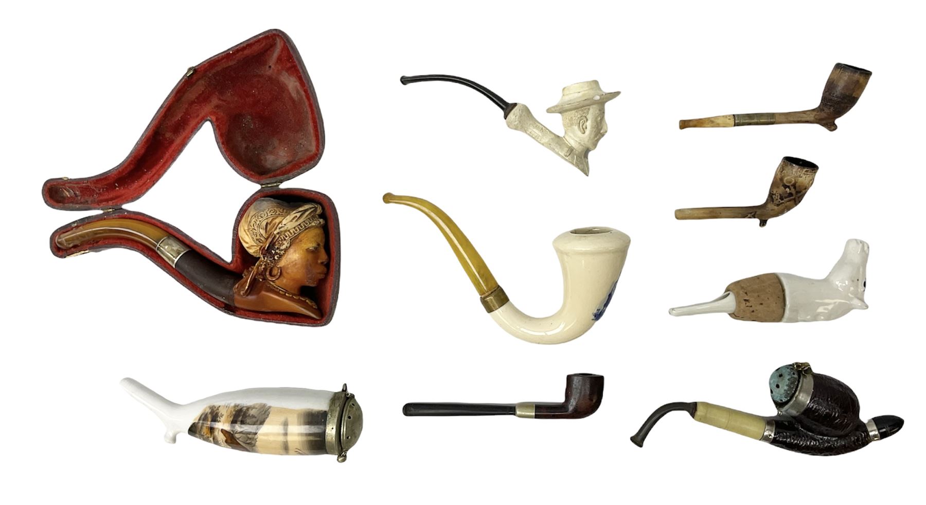 Carved meerschaum and amber pipe with silver mount, the bowl carved as a woman, cased, clay pipe in the form of an acorn, ceramic pipe, five other pipes and a ceramic bottle pourer in the form of a horse  