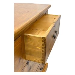 Pine dresser, rectangular top above seven drawers, with two smaller drawers over five larger drawers, all fitted with cast metal handles, raised on a shaped plinth base

