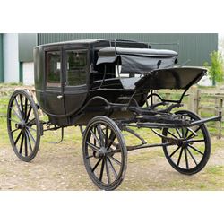 Town Coach by John Marstons Birmingham - Ex Film

A black painted five glass Town Coach by John Marston's Carriage Works Ltd, Birmingham, with enclosed glazed passenger compartment, curved front glass, external coachman's box seat and pole for driving with a pair of horses. The carriage has a timber coach body with buttoned black leather interior, blue upholstered seat cushions, plated exterior door handle, maker plates to the body and step, and John Marston marked hub caps. Mounted on black painted wooden spoked wheels with rubber tyres, leaf spring suspension, underbody turntable steering and iron fittings throughout.
Featured on the film set of 'Victoria' with Jenna Coleman

Features

• Black painted enclosed coach body
• Glazed passenger compartment with five windows
• Curved front glass
• Buttoned black leather interior
• Blue upholstered seat cushions
• External coachman's box seat
• Timber coach body
• Wooden spoked wheels
• Rubber tyres
• Leaf spring suspension
• Underbody turntable steering
• Pole for pair of horses
• Iron foot steps
• Plated exterior door handle
• Maker plates for John Marston's Carriage Works Ltd, Birmingham
• John Marston marked hub caps
• Featured on the film set of Victoria with Jenna Coleman

Dimensions:
Overall length: 390 cm
Width: 190 cm
Height: 214 cm

Wheel Diameters:
Front wheels: 104 cm
Rear wheels: 134 cm

Seating:
Coachman's box: 2
Passenger compartment: 4