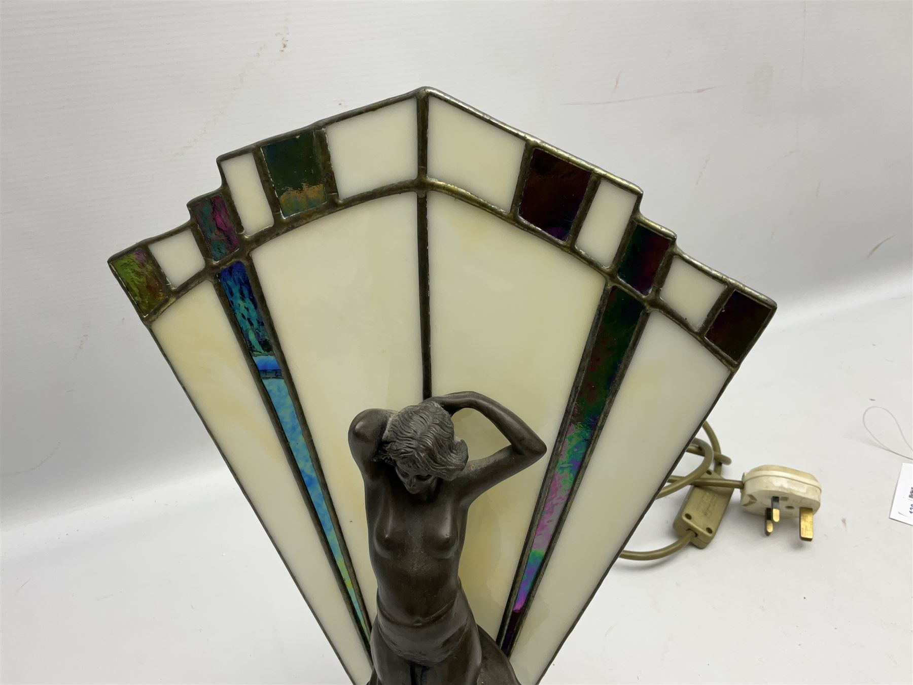 Art Deco style table lamp, modelled in the form of a bronzed female figure before a leaded glass fan shaped shade, H38cm