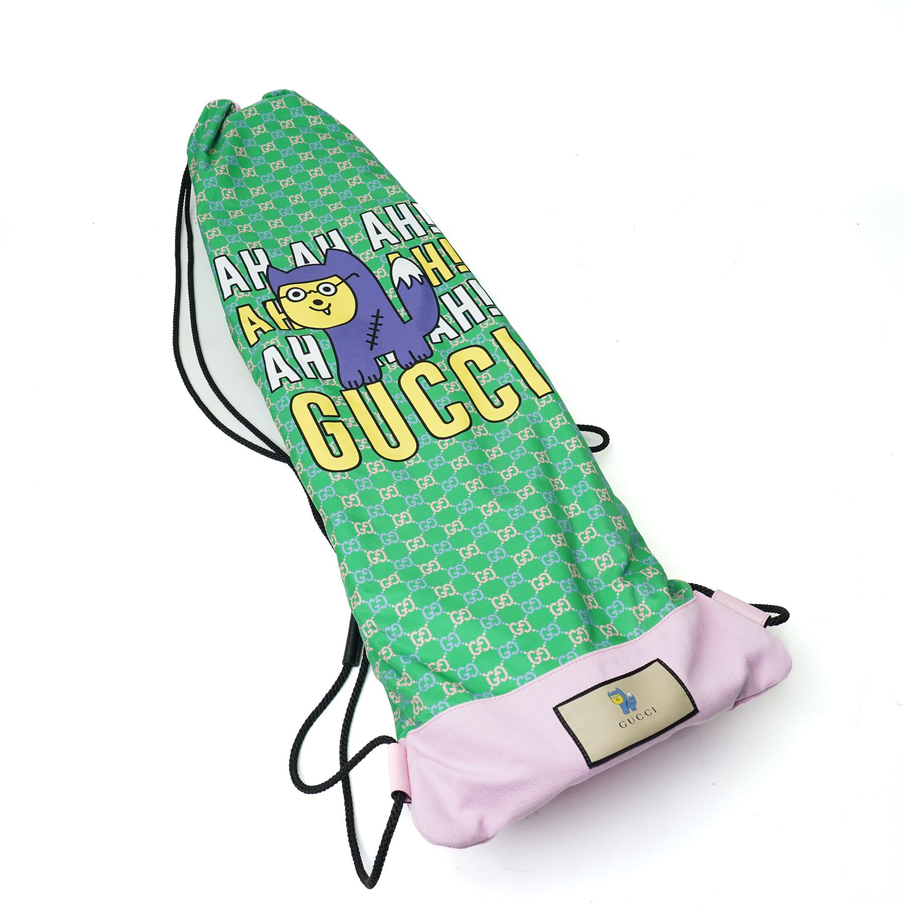 Gucci x Palace skateboard, Spring/Summer 2021, green GG monogram wood deck with multicolour ‘AH AH AH! GUCCI’ lettering and cartoon character mascot motif, fitted with Gucci-branded metal trucks and red and cream wheels, model no. 689103 JCGMN, presented with original GG monogram drawstring dust bag, protective sleeve, outer box and accompanying cards, Skateboard L81cm W20cm