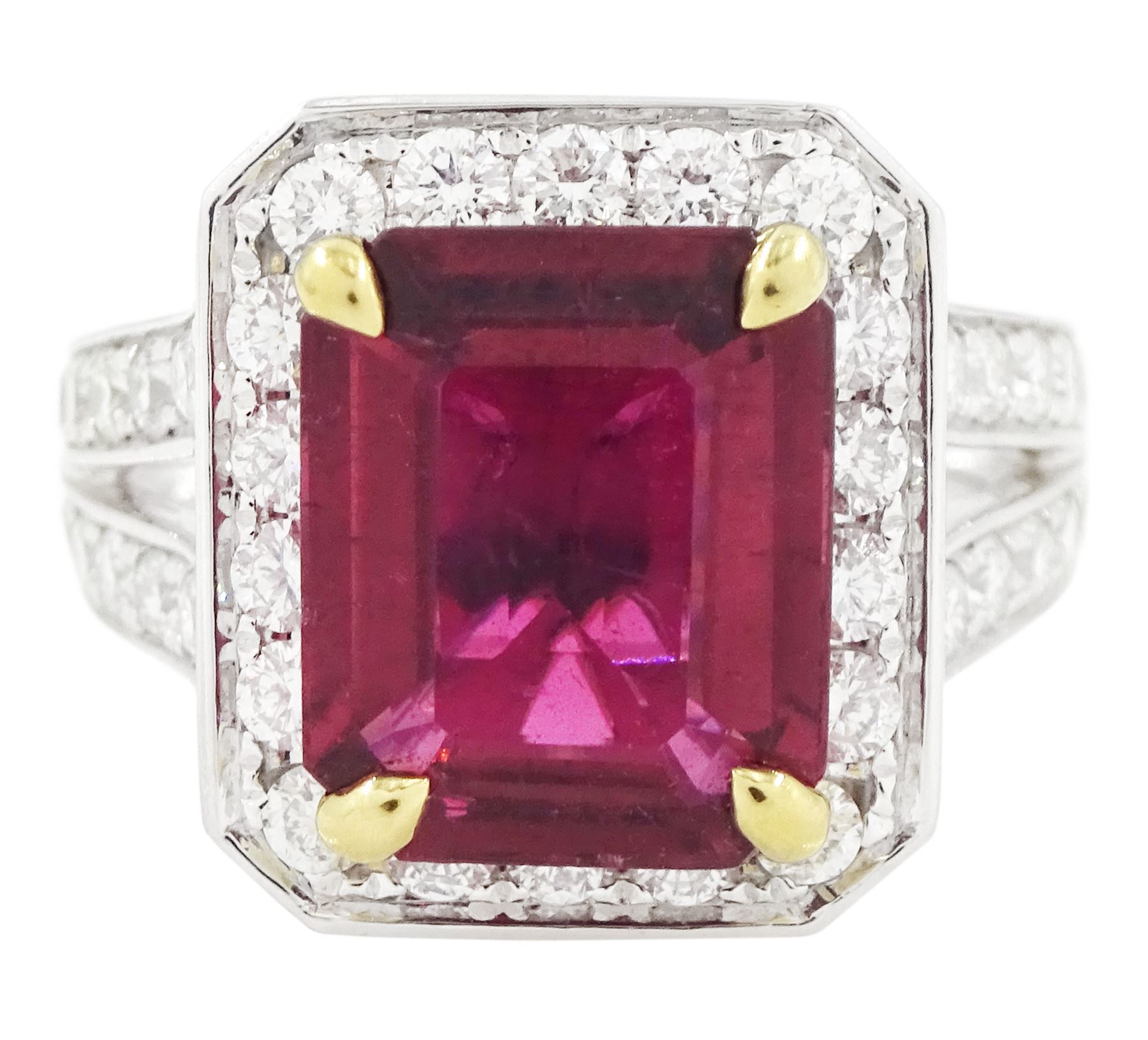 18ct white gold rubellite tourmaline and diamond cluster ring, single octagonal cut tourmaline of 4.05 carat, four claw set in yellow gold, surrounded by  round brilliant cut diamonds, with split diamond set shoulders, London 2013, total diamond weight 1.24 carat