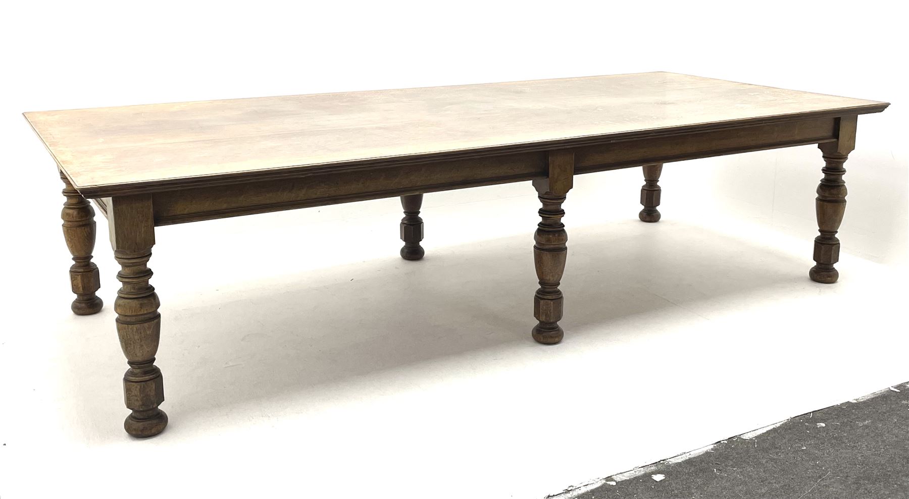 Large early 20th century oak boardroom table, rectangular moulded top on six turned and faceted supports 
