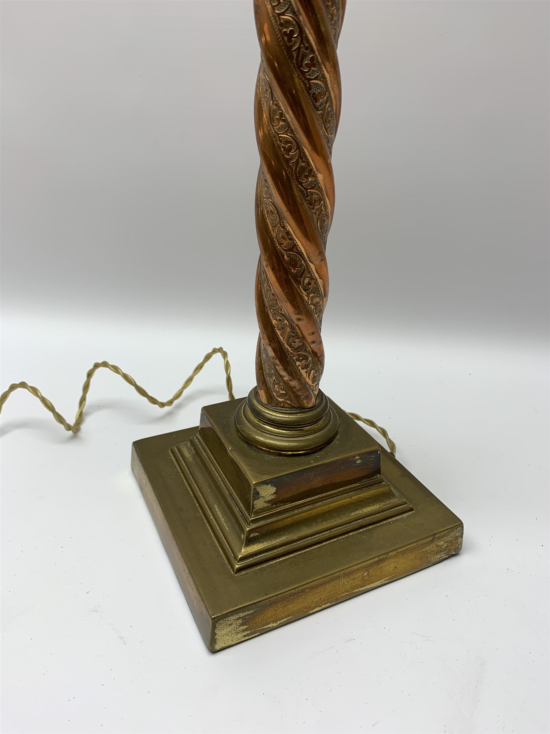 Early 20th century brass and copper Corinthian column table lamp, the square stepped brass base leading to a spiral twist copper column and brass Corinthian capital, H44.5cm 