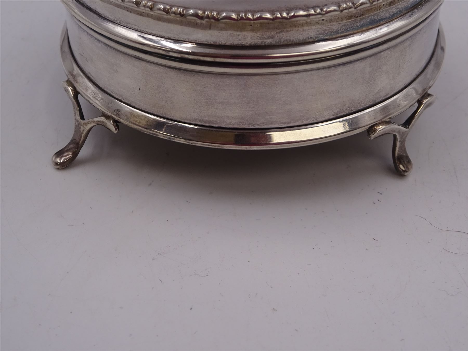 1920s silver mounted jewellery box, of circular form, with bead and dart rim to hinged cover, opening to reveal gilt velvet lined interior, upon four pad feet, hallmarked Charles Edwards, London 1920, H4.5cm