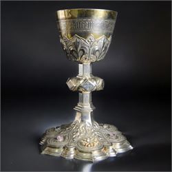 20th Century silver plated Gothic chalice, embossed throughout with fleurs de lis, foliate and bead decoration, on a knopped stem with flared and cusped foot, inset with three amethyst and two blue paste stones and applied paste and split pearl brooch, engraved beneath 'In Memory of my Mother R.I.P ... Aug 15th 1937, H23cm