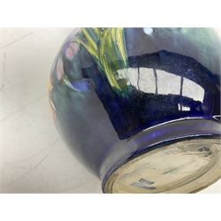 Moorcroft vase of baluster form decorated in the Spring Flowers pattern upon a merging green and blue ground, with impressed and painted marks beneath, H22.5cm