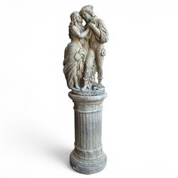 Composite garden statue group of Romeo and Juliet embracing, the couple adorned in Medieval dress standing on a naturalistic base with fallen flowers, raised on a Neoclassical fluted pedestal with Anthemion leaf motifs