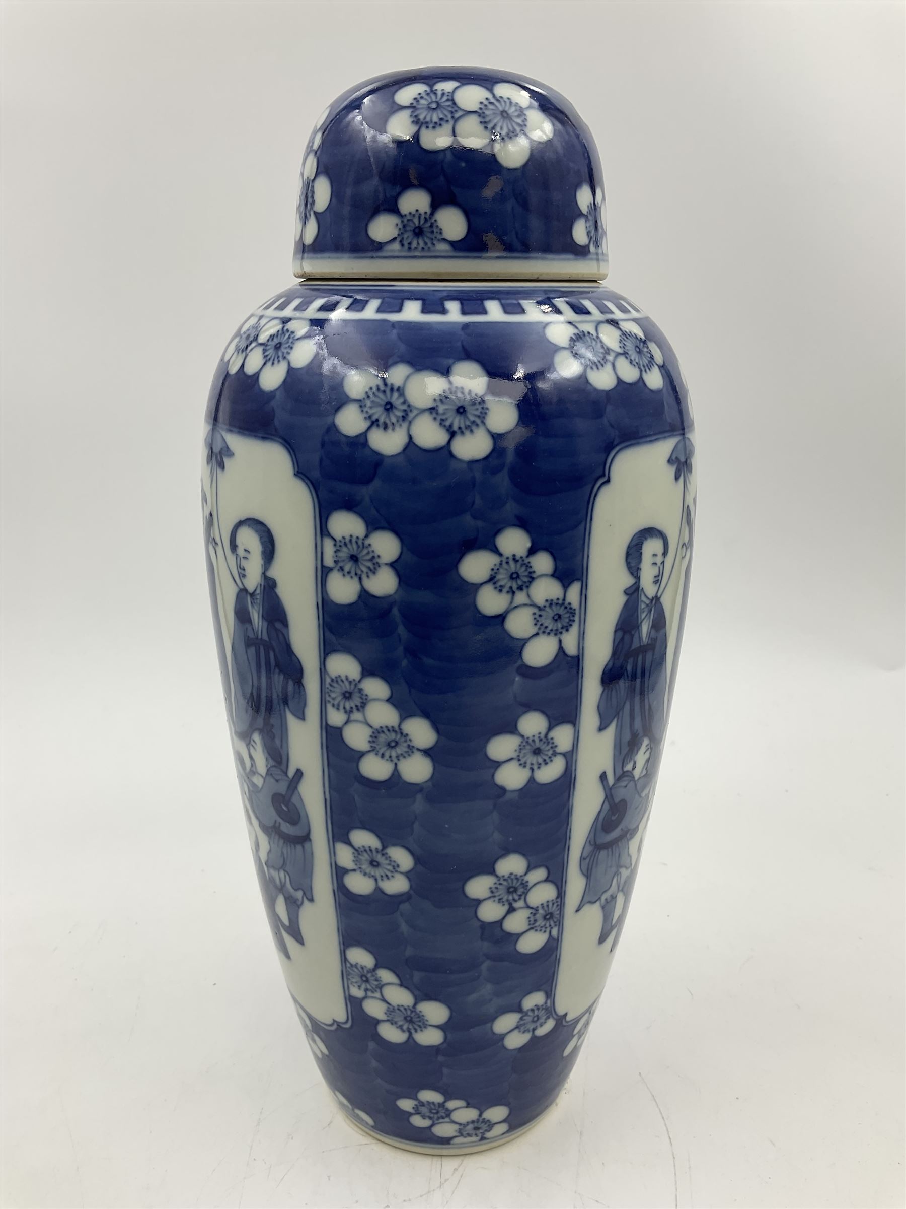 Late 19th century Chinese blue and white jar and cover, of slender ovoid form with domed cover, decorated with two reserves containing figures, against a prunus blossom ground, with Kangxi type mark beneath, H27.5cm