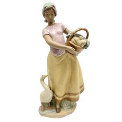 Lladro figure, Daily Chores, modelled as a lady holding a basket with a goose at her feet, Gres finish, sculpted by Marco Antonio Nogueron, with original box, no 12329, year issued 1995, year retired 1999, H34cm
