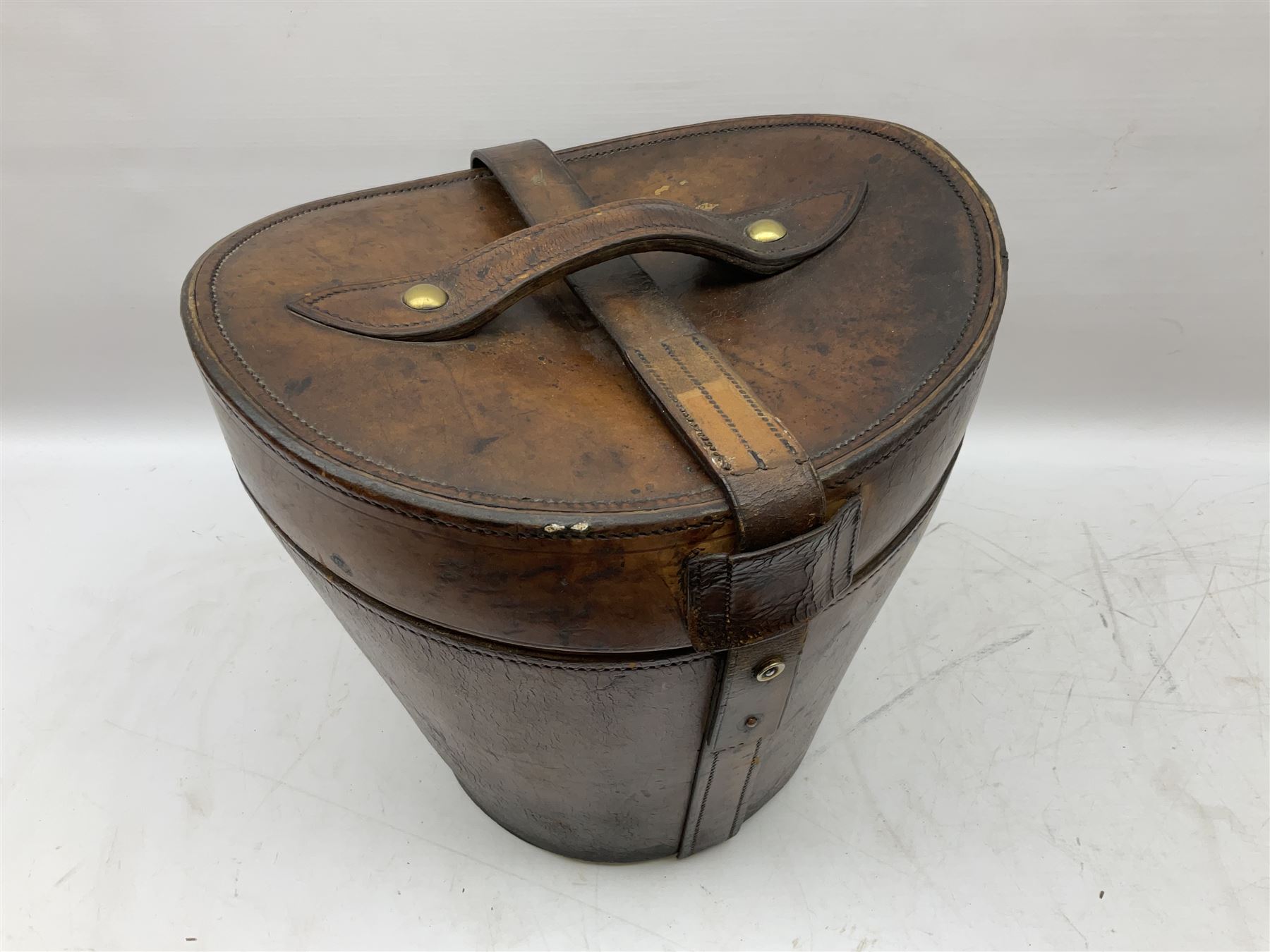 Early 20th century black silk top hat by Woodrow of Manchester and London, with manufacturer's stamp to the silk lined interior, housed in fitted tan leather hat box with removable internal compartments with straps, brass escutcheon and engraved plaque, hat internal measurements approx 20cm x 15cm
