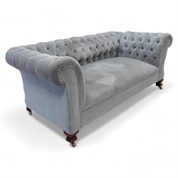 Early 20th century Chesterfield drop-arm two-seat settee, traditional shape with rolled arms and back, upholstered in buttoned pale blue fabric, on ogee block feet with brass castors 