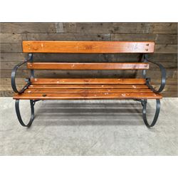 Wrought metal scrollwork and wood slatted garden bench