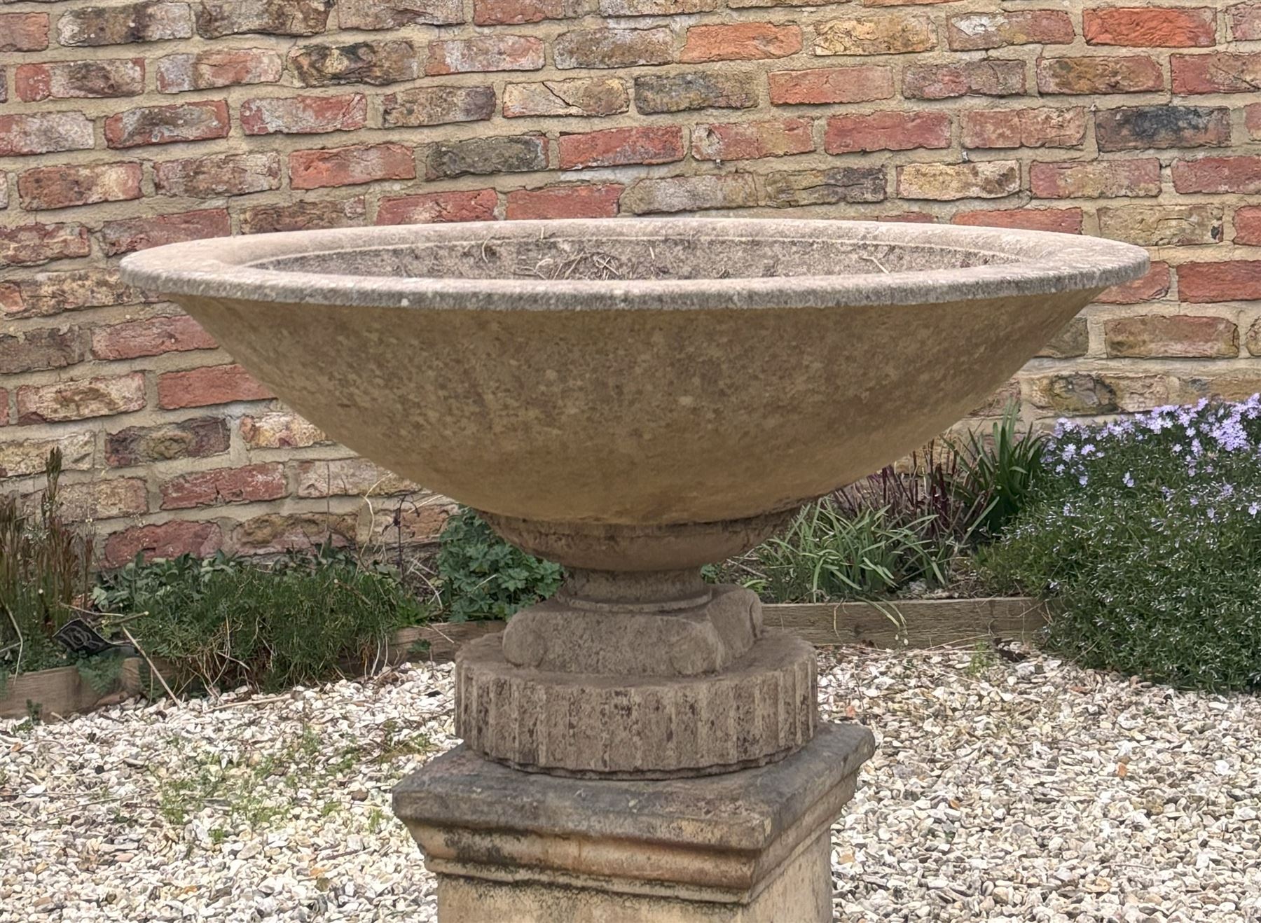 Reconstituted stone shallow urn / bowl planter, raised on a scrolled and fluted base. H43cm, D87cm. - COLLECTION BY APPOINTMENT FROM: The White House, Thirsk Road, Easingwold, York, YO61 3NF - CALL 01723 507111 TO ARRANGE