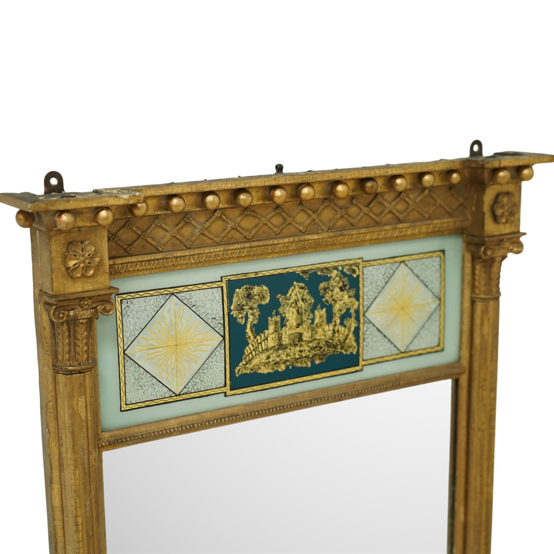 Regency period giltwood and verre-eglomise mirror, gilded frieze with trellis and ball design flanked by paterae and gilded beading beneath, above a large reverse painted glass panel depicting a monastic building between stylized diamond design with striations, gilded and hand-painted on glass flanked by Corinthian capitals above fluted columns between the original mirror plate above a stepped and beaded moulded base, circa 1815


Provenance: No. 1 Charlotte Square, New Town, Edinburgh.