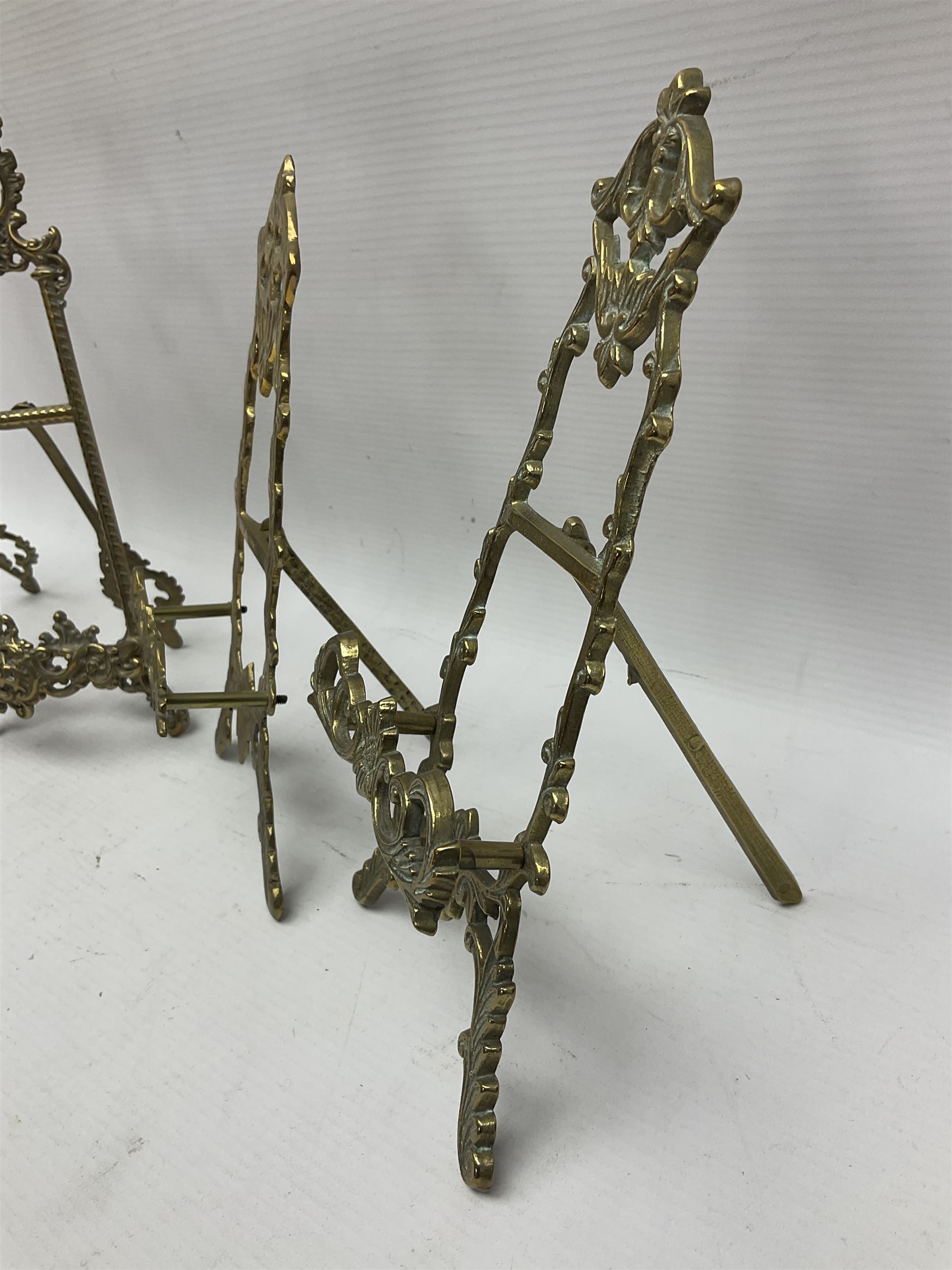 Nine ornate cast brass easel stands of various sizes, H24cm