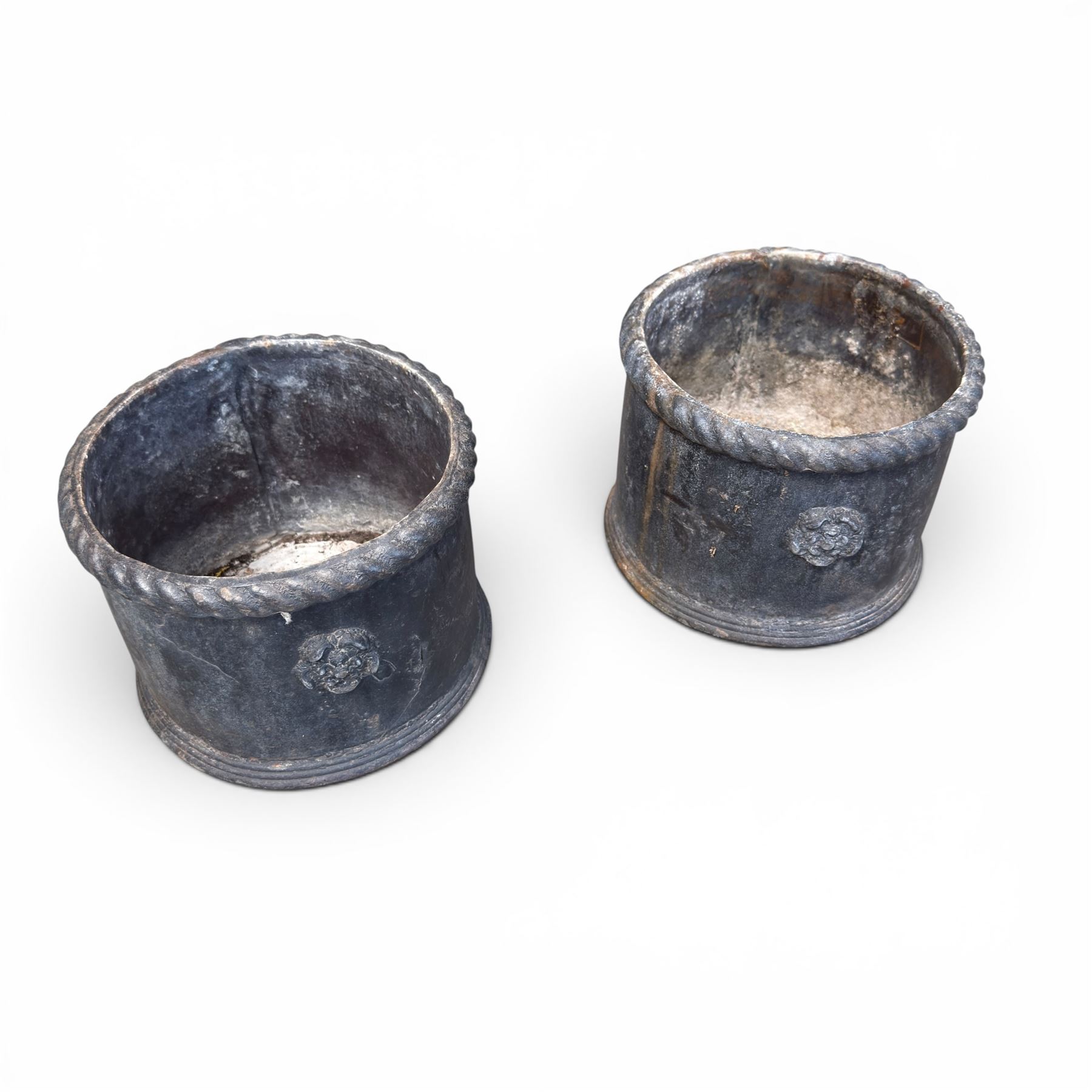 Pair of 19th century lead garden planters of cylindrical form, the rolled rope twist rims over a plain body decorated with applied flowerhead roundels, in antique weathered finish