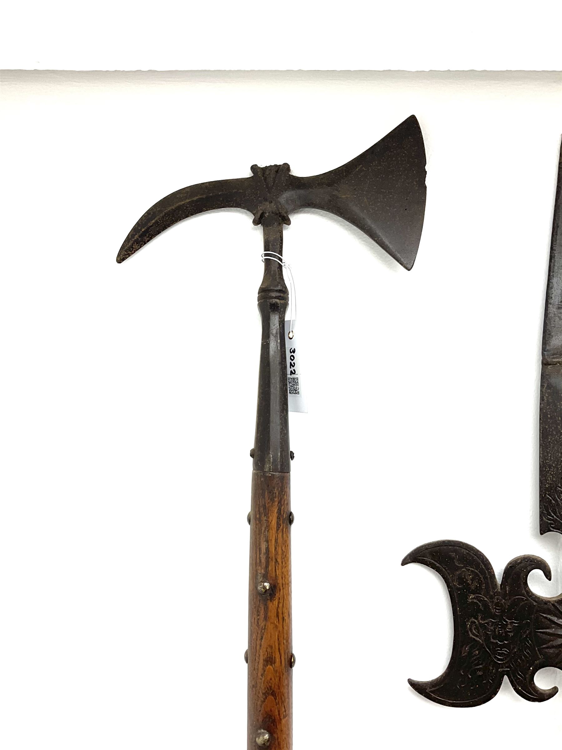 Large continental steel halberd axe the engraved blade with cast sunburst centre and long studded ash handle L219cm; and another halberd with plain ribbed blade and studded ash handle with ground spike (2)