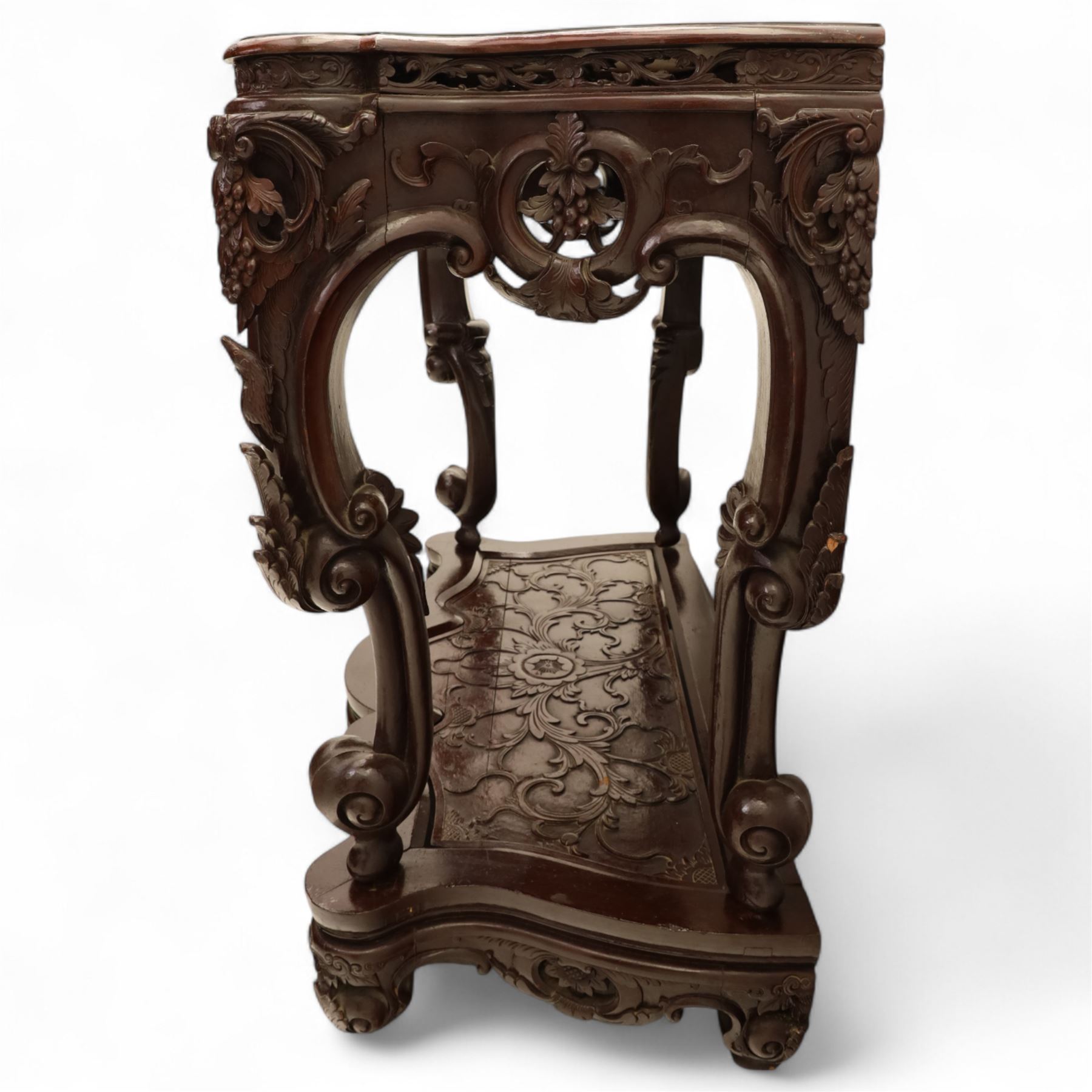 Chinese stained hardwood side table, late Qing dynasty style, with shaped top above a pierced and carved frieze of foliage and fruiting vines, cabriole legs terminating in scroll feet, united by a carved shaped undertier
