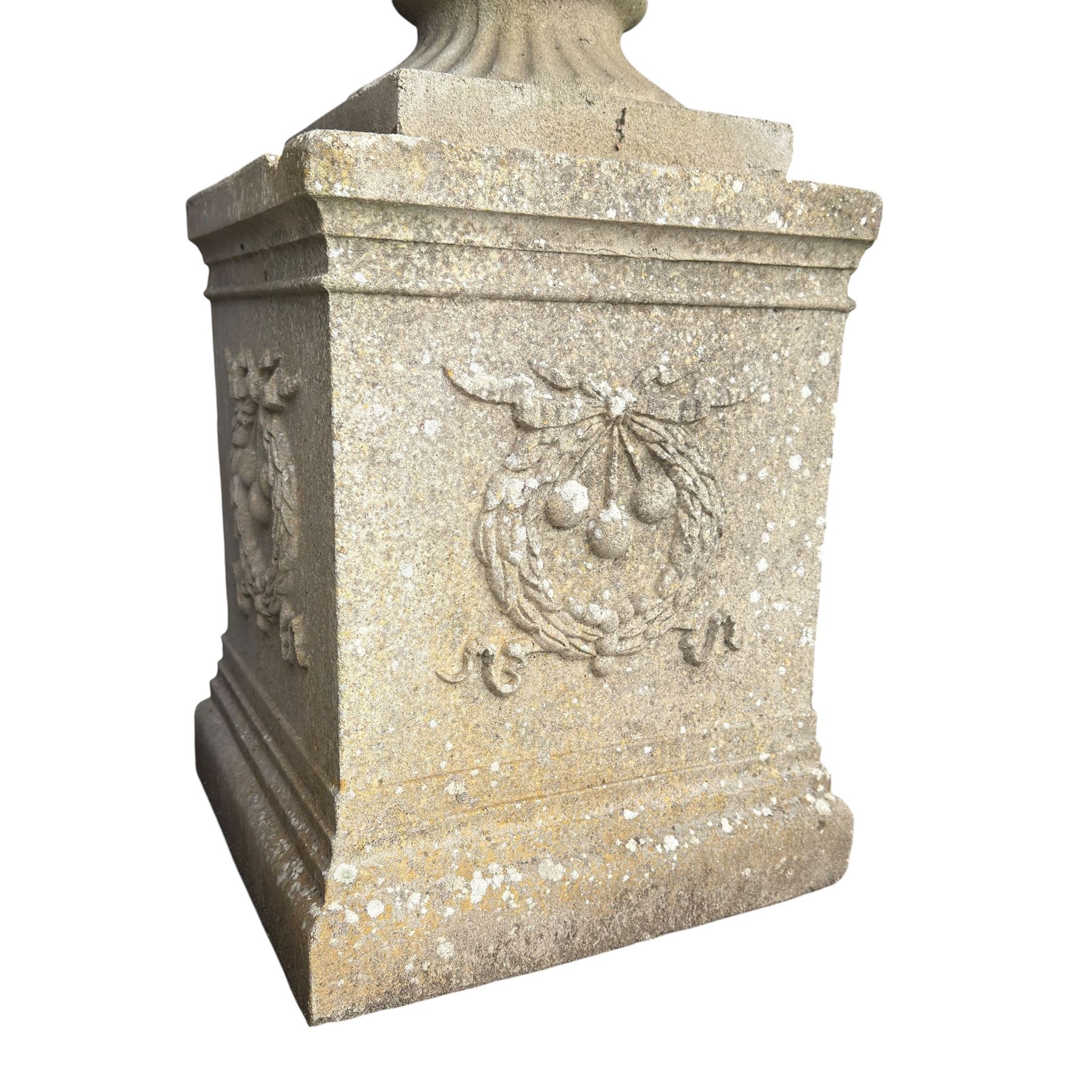 Pair of quality Neoclassical design Haddonstone cast stone garden urns, the globular  body decorated with relief foliate festoons and fruiting motifs, over a fluted socle, the rectangular pedestals with relief foliate wreaths and ribbon garlands