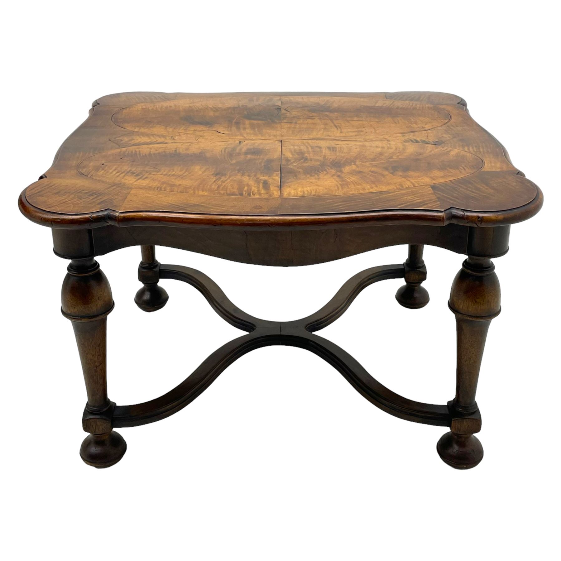 Figured mahogany coffee table, shaped moulded top with oval book-matched veneered panels, on turned supports united by waved X-shaped stretchers 