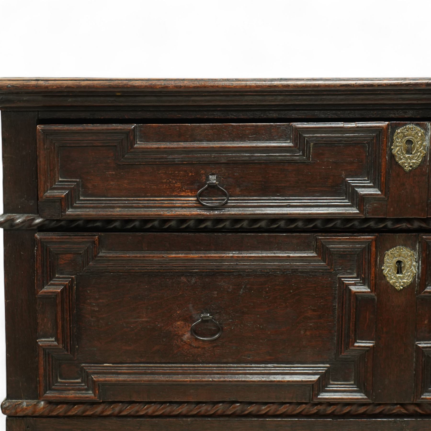 Late 17th-century oak chest, rectangular top above four graduated drawers with geometric panel mouldings, in two sections, supported on bun feet 