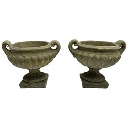 Pair of cast stone garden squat urns, shallow bowl shape with scrolled handles, gadroon moulded underbelly, circular fluted foot on square base 