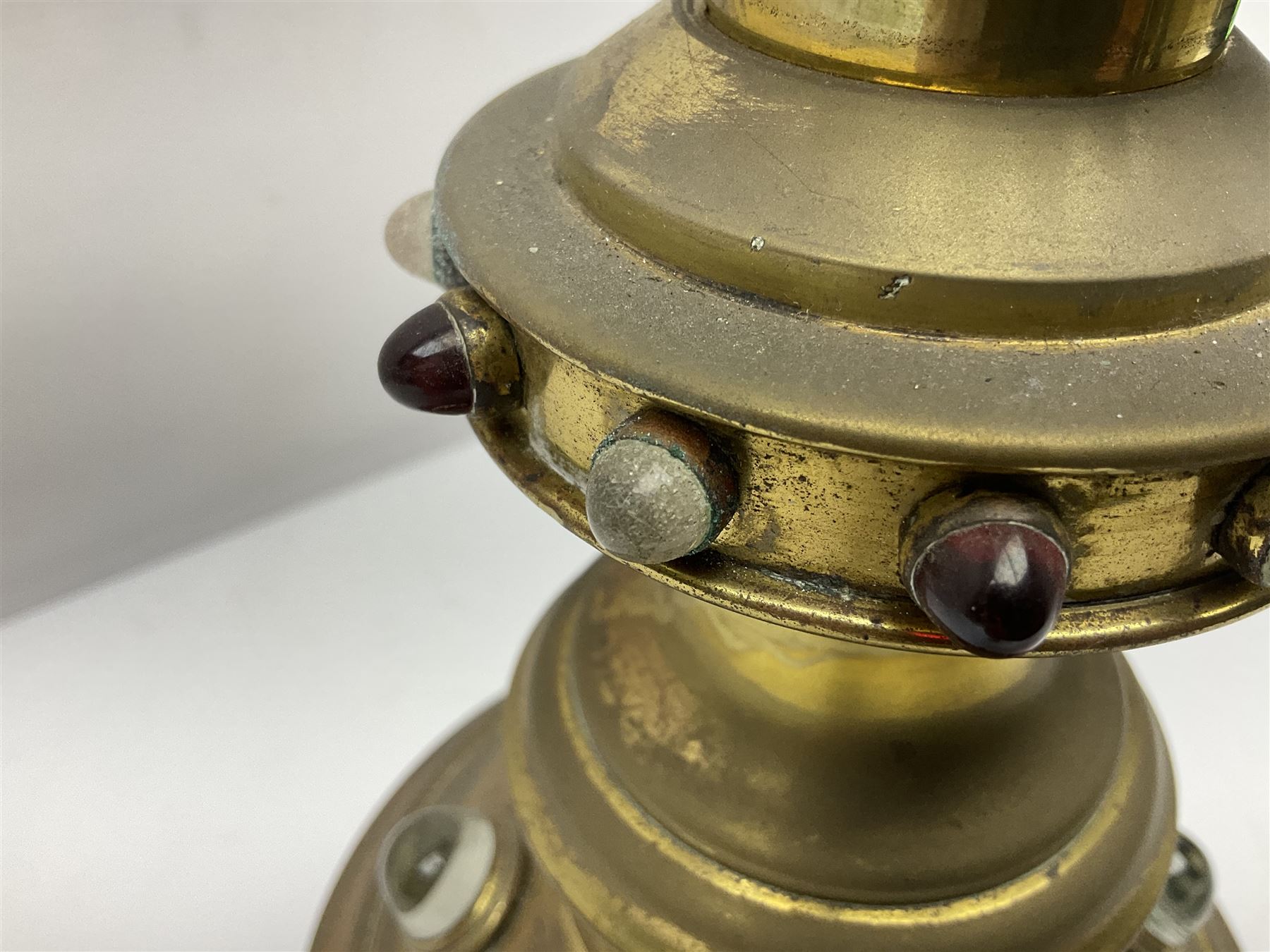 Brass alter cross, decorated with glass cabochons, upon a acicular stepped base and three claw feet, H73cm 