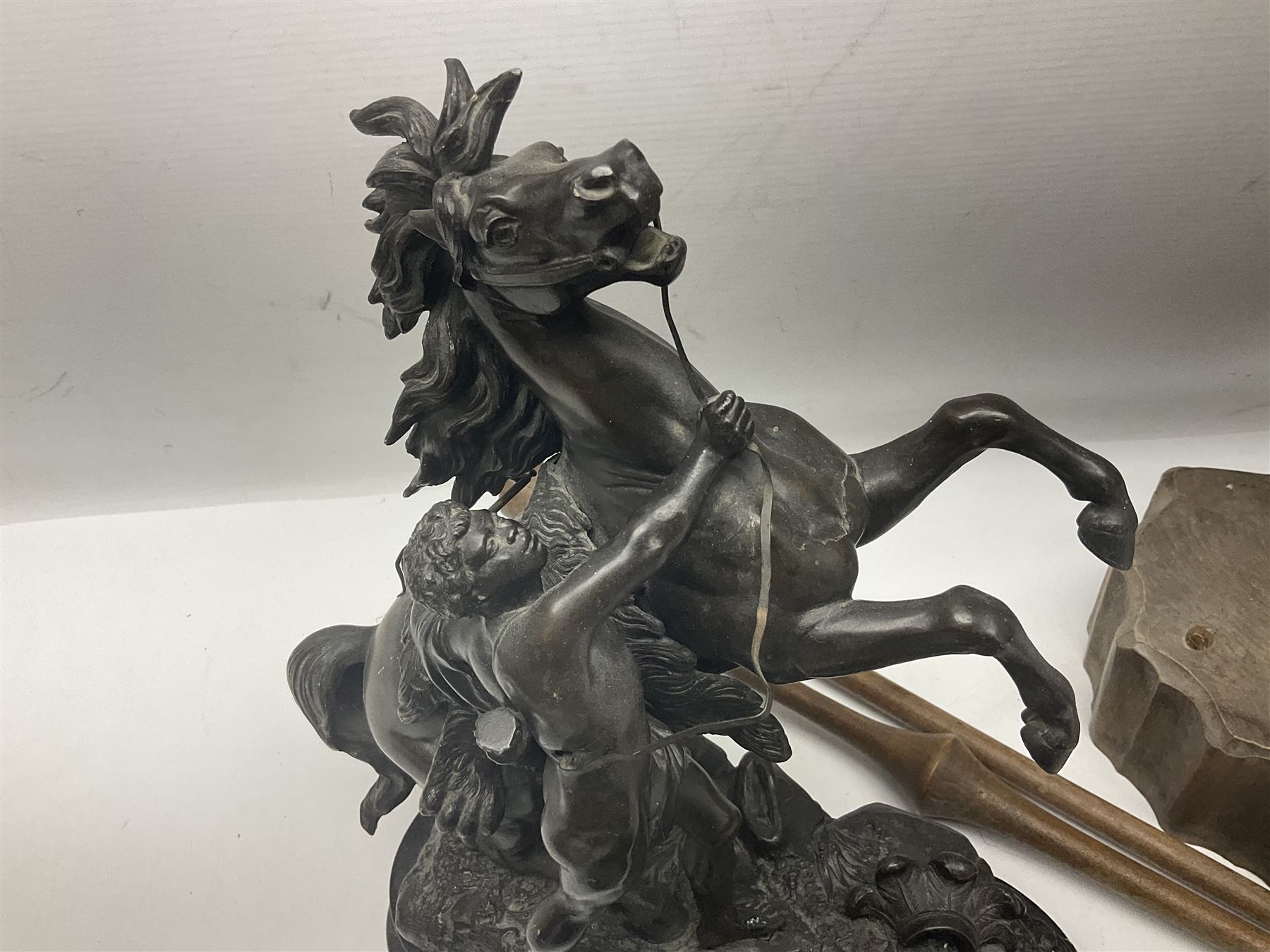 Spanish carved figure of Don Quixote, holding a book, base stamped 'Ouro, together with two spelter figures and one other